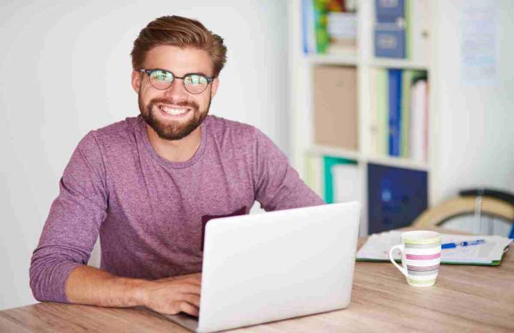 uomo che sorride con il pc