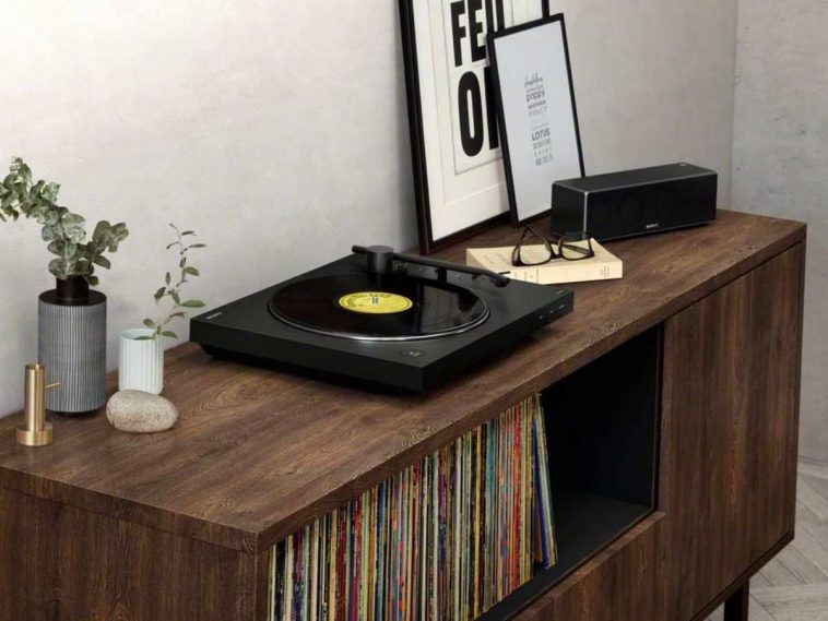 giradischi nero sony sopra mobile in legno accanto a cornice