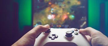 mani su controller con sfondo gioco