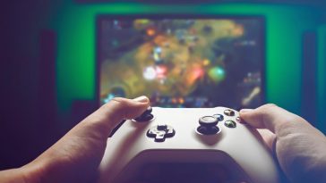 mani su controller con sfondo gioco