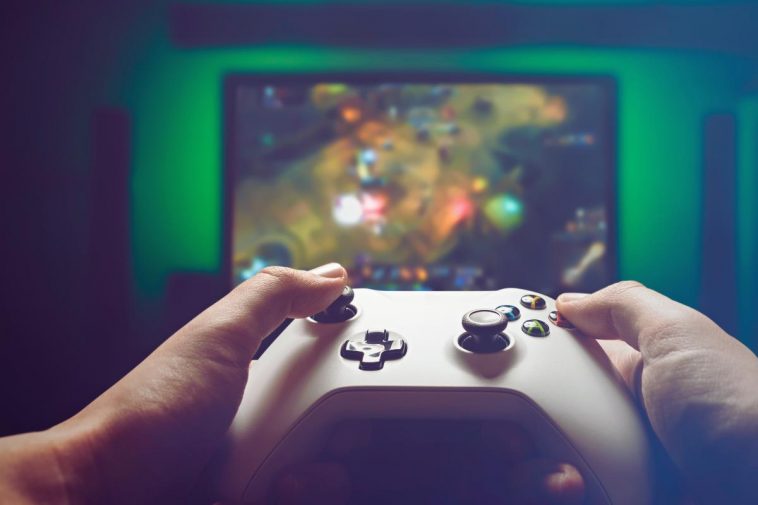 mani su controller con sfondo gioco