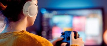 donna che gioca al videogioco con le cuffie