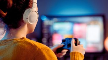 donna che gioca al videogioco con le cuffie