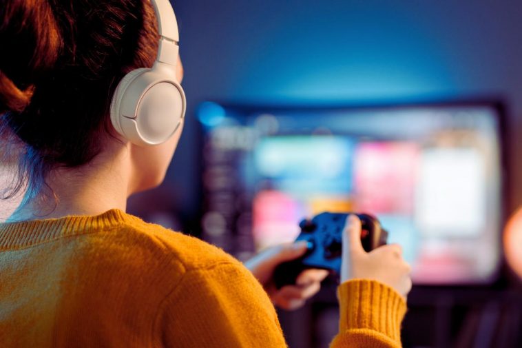 donna che gioca al videogioco con le cuffie